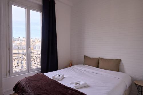un lit dans une chambre avec une grande fenêtre dans l'établissement Bright 1BR Parisian Retreat Italy Square | By Airnest, à Paris