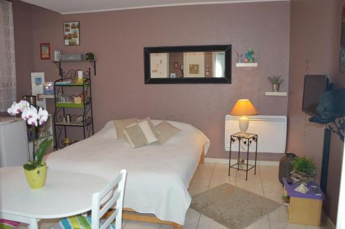 een slaapkamer met een bed, een tafel en een spiegel bij Le Campanin in Menton