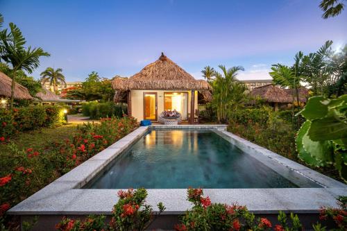 a swimming pool in front of a villa at Outrigger Fiji Beach Resort in Korotogo