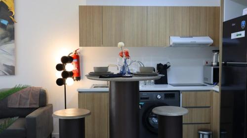 a small kitchen with a table and a stove at Terminal 1BR Retreat - Modern Comfort & Chic Stay in Abu Dhabi
