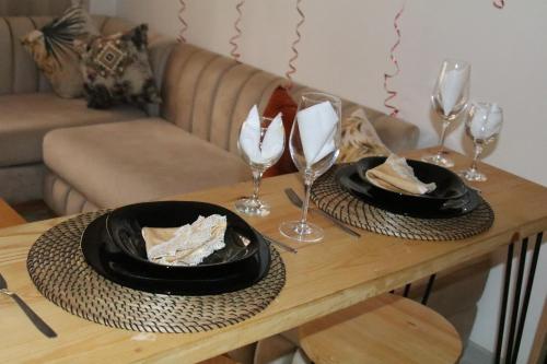 a table with two plates of food and wine glasses at Élégance en 40 mètres Nouaceur in Nouaceur