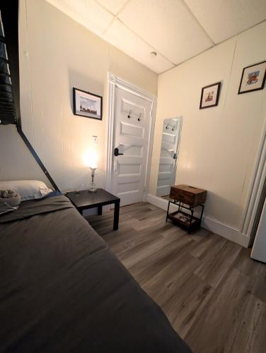 a room with a bed and a table and a door at Boston Homestel in Boston