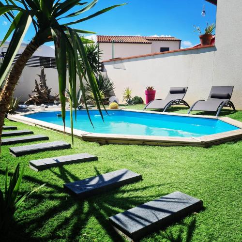 - une piscine dans une cour avec des chaises et un palmier dans l'établissement Villa Cami del Paradis, à Corneilla-del-Vercol