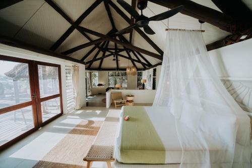 a bedroom with a bed with a mosquito net at Yasawa Island Resort & Spa in Mbukama