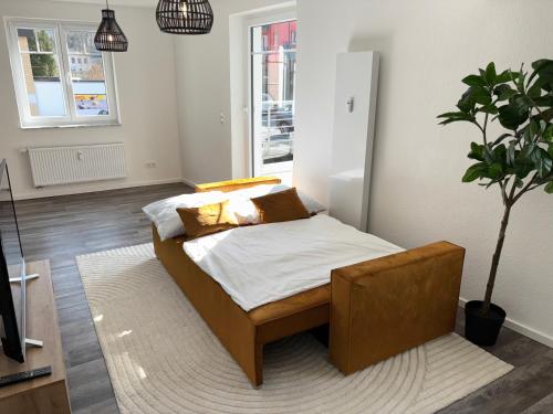 a bedroom with a bed and a potted plant at Im Herzen der Eifel - Entspannung pur in Hellenthal