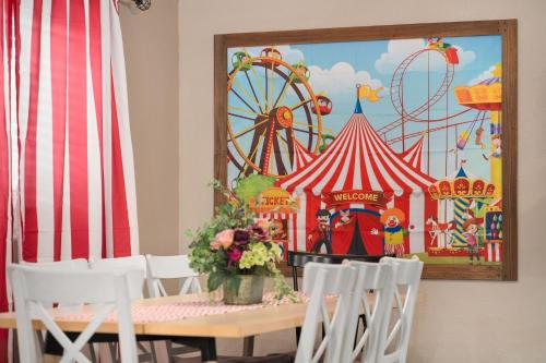 a table with chairs and a carnival picture on the wall at Carnival Dream - Arcades, Carousel, Playground and more! in Orange