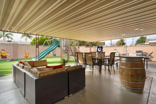 a patio with a table and chairs and a playground at Carnival Dream - Arcades, Carousel, Playground and more! in Orange