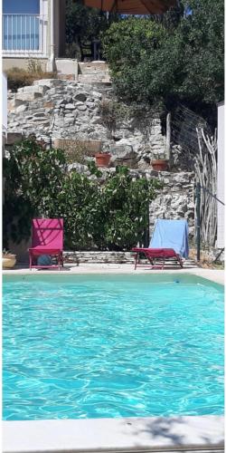 - deux chaises roses et bleues à côté de la piscine dans l'établissement Maison provençale Piscine calme et soleil Très proche d'un arrêt de bus, à Villeneuve-lès-Avignon
