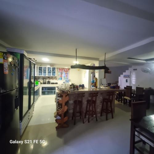 a kitchen with a bar with stools in it at Hosteria Cattleya in San Andrés