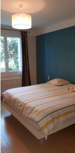 une chambre avec un grand lit avec un mur bleu dans l'établissement Maison provençale Piscine calme et soleil Très proche d'un arrêt de bus, à Villeneuve-lès-Avignon