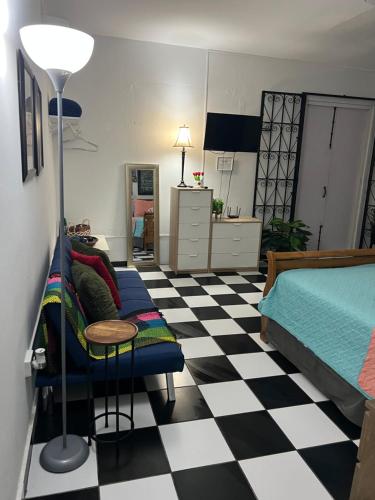 a bedroom with a bed and a checkerboard floor at 310Guest-House La Vida in San Juan