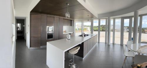 a kitchen with a white counter and some windows at Sunny Penthouse Central in Mosta