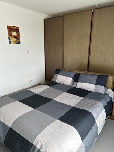 a bedroom with a large bed with blue and white stripes at Sunny Penthouse Central in Mosta