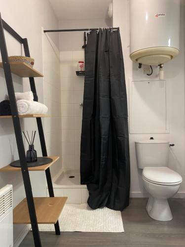 La salle de bains est pourvue d'un rideau de douche noir et de toilettes. dans l'établissement Spacieux T2 boulevards au pied du tram C, à Bègles