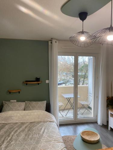- une chambre avec un lit, une table et une terrasse dans l'établissement Spacieux T2 boulevards au pied du tram C, à Bègles