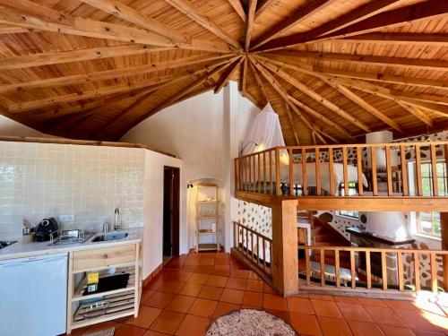 a kitchen with a wooden ceiling with a spiral staircase at The Mill - Sintra in Sintra