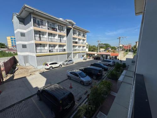 a parking lot with cars parked in front of a building at studio condo in urdaneta in Urdaneta
