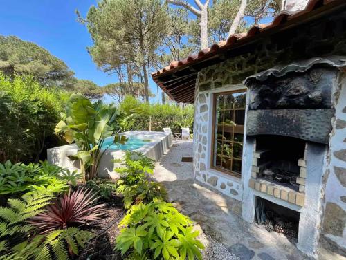 a garden with a stone fireplace next to a house at The Mill - Sintra in Sintra