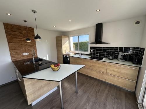 a kitchen with a table with a bowl of fruit on it at GWEL KAER - Maison tout confort petite vue mer in Plouarzel