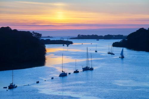 a group of boats in a river at sunset at GWEL KAER - Maison tout confort petite vue mer in Plouarzel