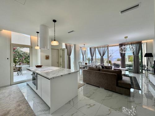a kitchen and living room with a couch and a table at Crystal Pool Villa, Green Coast, Palase in Palasë