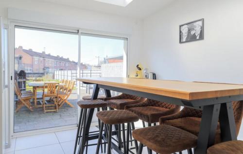 une cuisine avec une table et des chaises ainsi qu'une grande fenêtre dans l'établissement Chez Lulu Maison ville 4 chambres, à Dunkerque