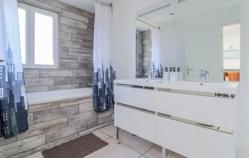 une salle de bain avec deux lavabos, une baignoire et un miroir dans l'établissement Chez Lulu Maison ville 4 chambres, à Dunkerque