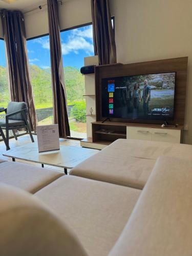 a room with two beds and a tv and windows at Villas Na-tiva Guanacaste in Plazuela