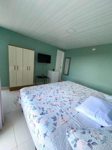 a bedroom with a bed and a tv in it at Pousada Pôr do Sol in Lapa