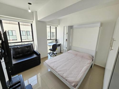 a bedroom with a bed and a chair and a desk at Habitación con baño privado en departamento compartido cerca de zona de conciertos in Mexico City