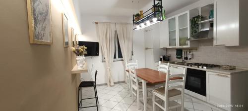 eine Küche mit Tisch und eine Küche mit weißen Schränken in der Unterkunft Casa A Pupidda vicino al mare in Avola