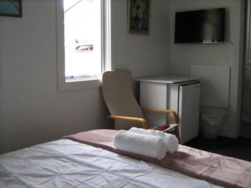 a bedroom with a bed with a towel on it at Downtown Backpackers & Accommodation in Nelson