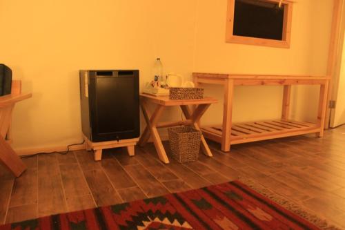 a living room with a television and a table at Albayt Private Camp in Wadi Rum