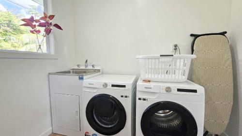a laundry room with a washing machine and a sink at TeMakatea Villa in Matavera