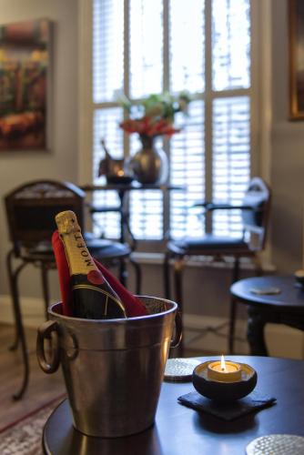 a bottle of champagne in a bucket on a table with a candle at Mama’s Inn Boutique Guest House in Nottingham