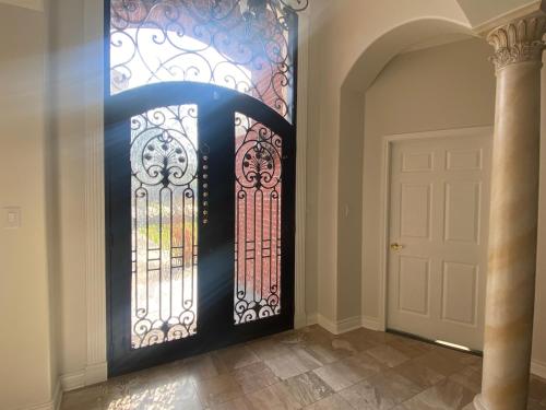 a hallway with a door with a wrought iron gate at La Casa De Francella in Houston