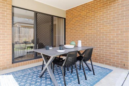 a table and chairs sitting next to a brick wall at Modern Clyde House Smart TV*Dryer in Clyde
