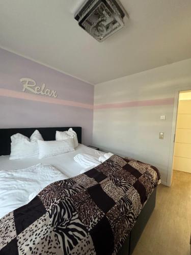a bedroom with a bed with a black and white blanket at Wohnung mit Garten und Whirlpool in Berlin