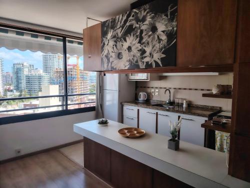 eine Küche mit einer Theke und einem großen Fenster in der Unterkunft Apartapunta in Punta del Este