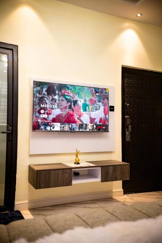 a living room with a television on a wall at B&M residence in Dawhwenya