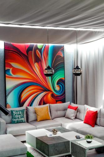 a living room with a couch and a colorful painting at B&M residence in Dawhwenya