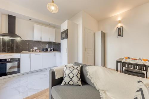 un salon avec un canapé et une cuisine dans l'établissement La Mini Bourgeoise, au Bourget