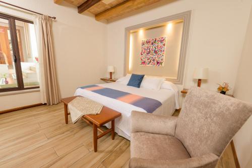 a bedroom with a bed and a chair and a couch at Hotel Casa Vertiz in Oaxaca City