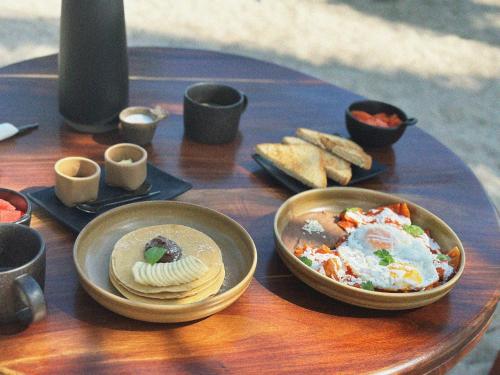 a table with bowls of food and bread on it at Cucu Hotel El Cuyo in El Cuyo