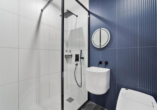 a bathroom with a shower and a toilet and a mirror at 호텔그랑파리 in Gwangju