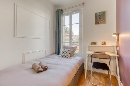 une chambre avec un lit, un bureau et une fenêtre dans l'établissement La Mini Bourgeoise, au Bourget