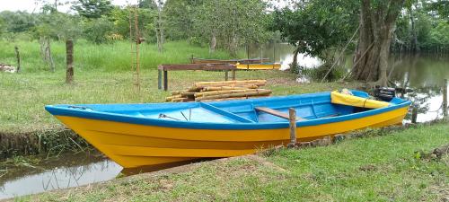 a blue and yellow boat sitting in the water at Sconfra creek in Bluefields
