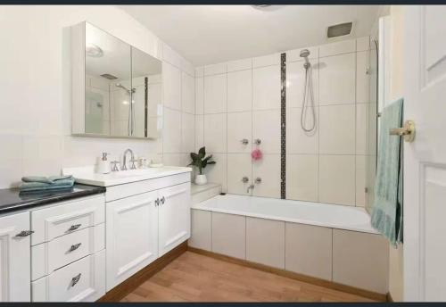 un bagno bianco con vasca e lavandino di Cosy Cottage 2br Ballarat Stay Close To Cbd a Ballarat