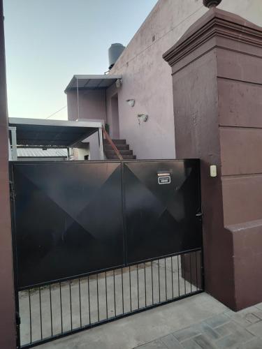 a black gate in front of a building with stairs at Don Oscar Alojamientos Dpto Sol in San Justo