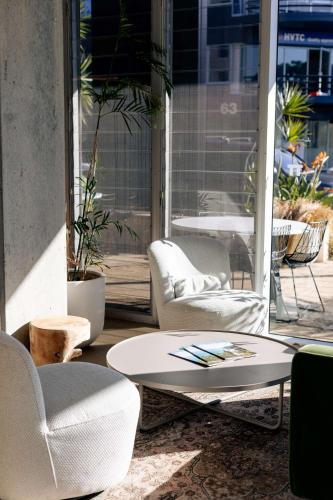 a room with two chairs and a table and chairs at Hotel TOTTO Wollongong in Wollongong
